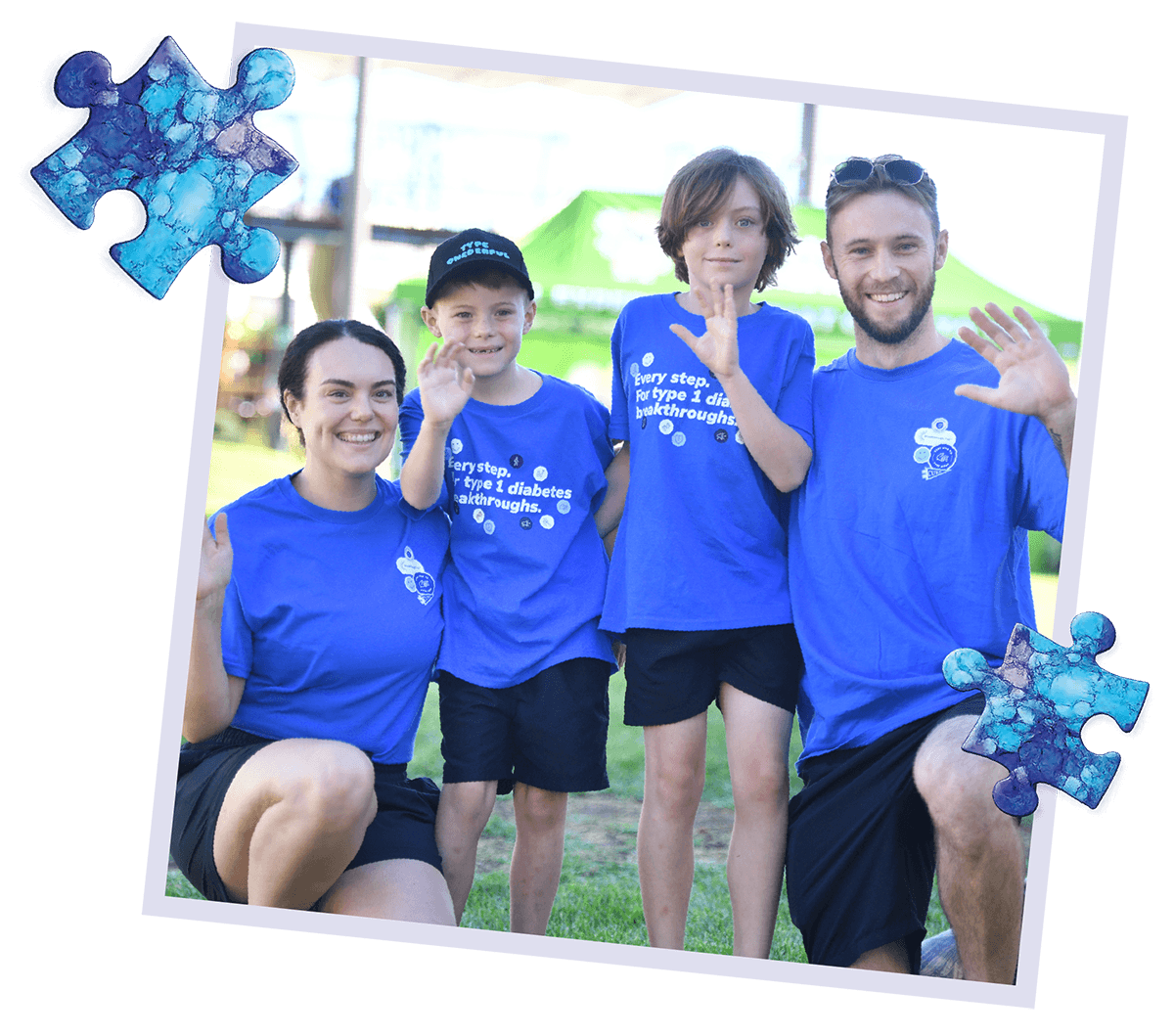 A family in Breakthrough T1D branded blue T-shirts smile together at an outdoor event.