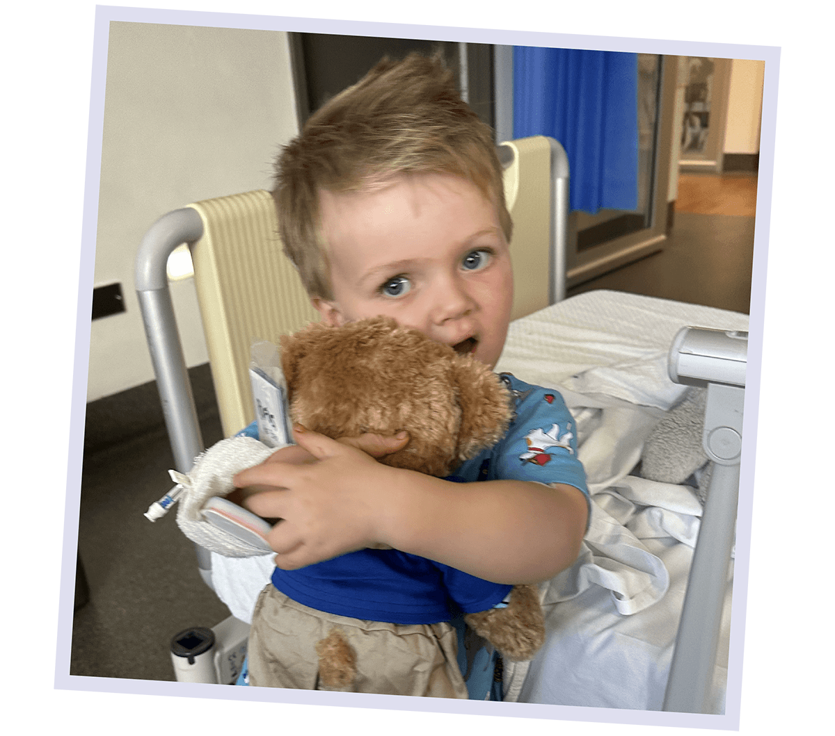 Fletcher hugging a teddy bear in hospital