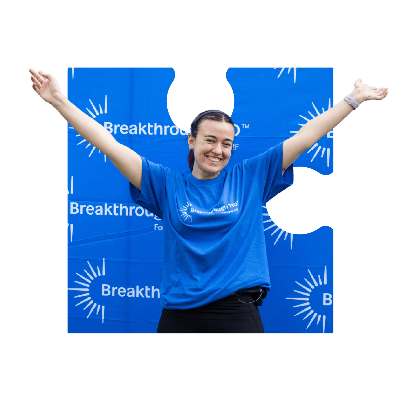 A woman in a Breakthrough T1D branded blue T-shirt smiles at an outdoor event.